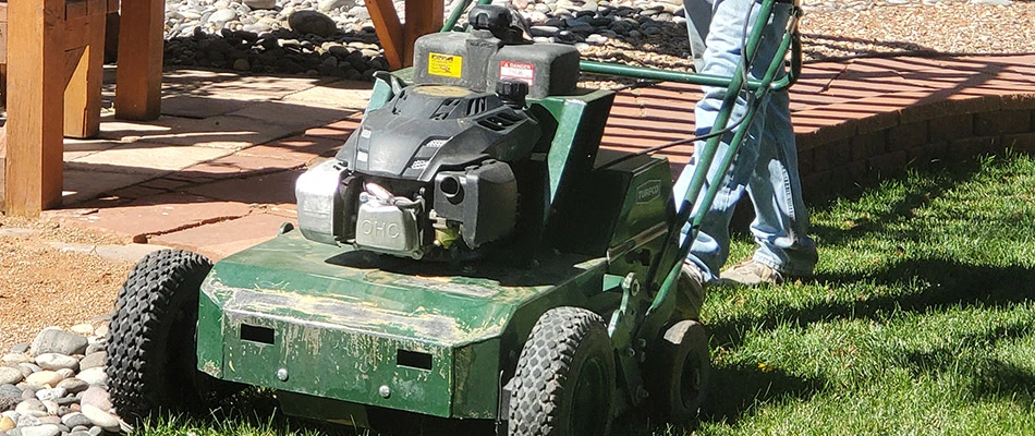 Mesa Turf Masters professional using core aerator machine in a lawn in Grand Junction, CO.