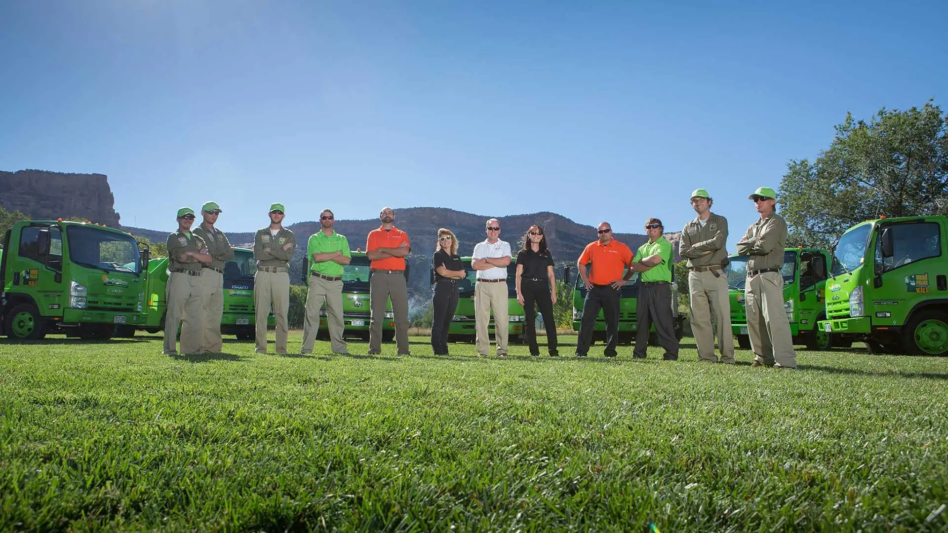 The Mesa Turf Masters team with company trucks on a sunny afternoon in Grand Junction, CO.